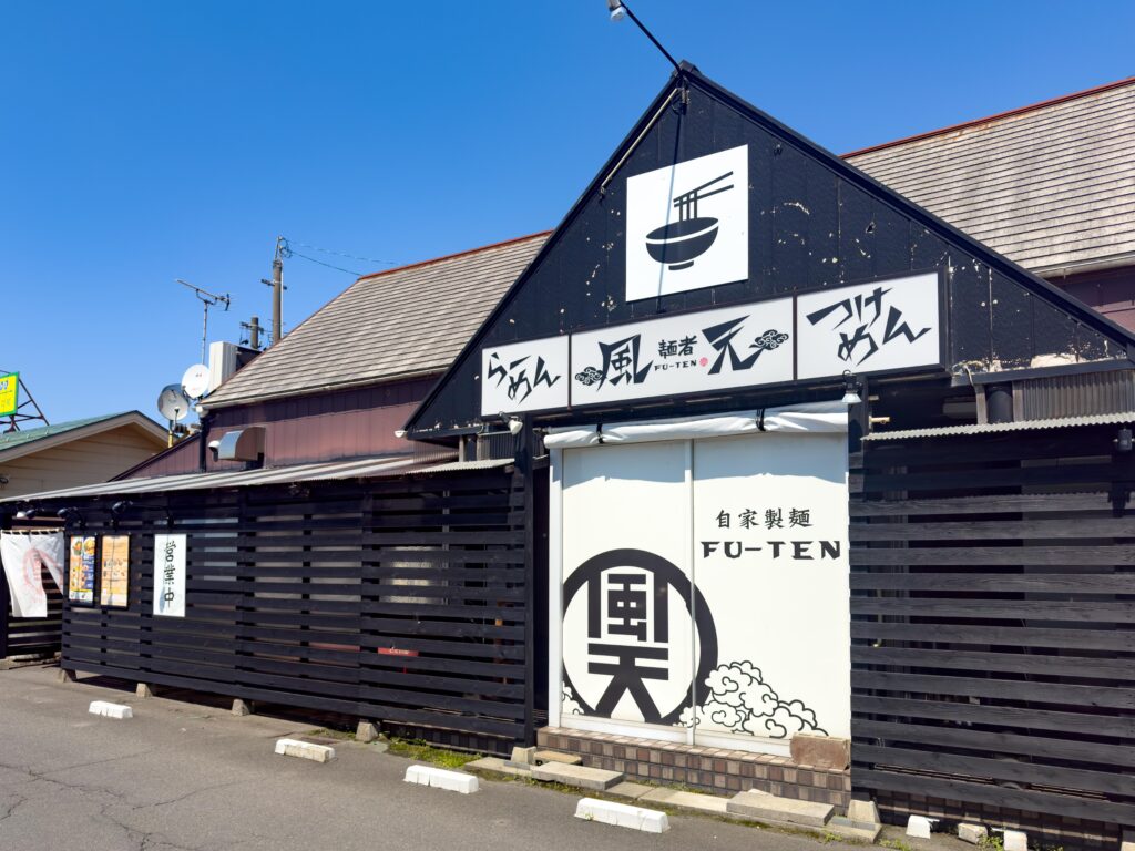 黒を基調とした「麺者 風天 亀田店」の外観。個性的なロゴが目を引く店舗デザイン。