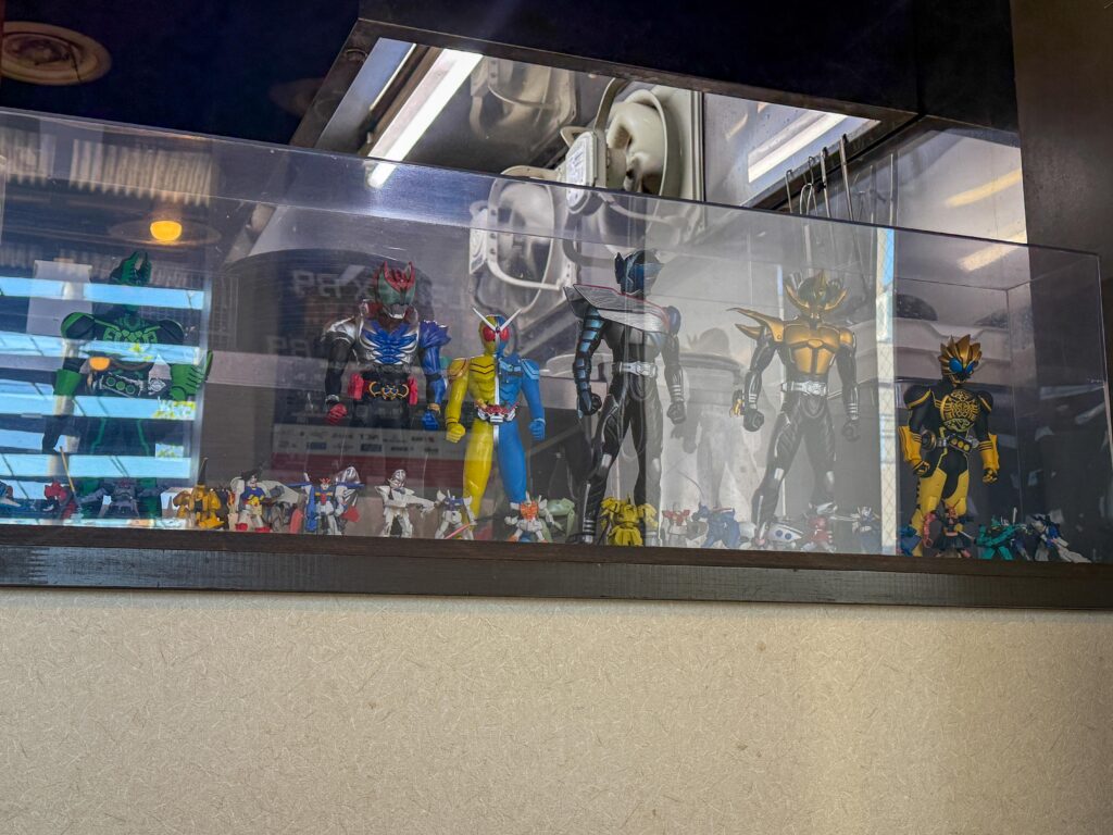 店内カウンターに飾られた特撮ヒーローやガンダムのフィギュアコレクション。
