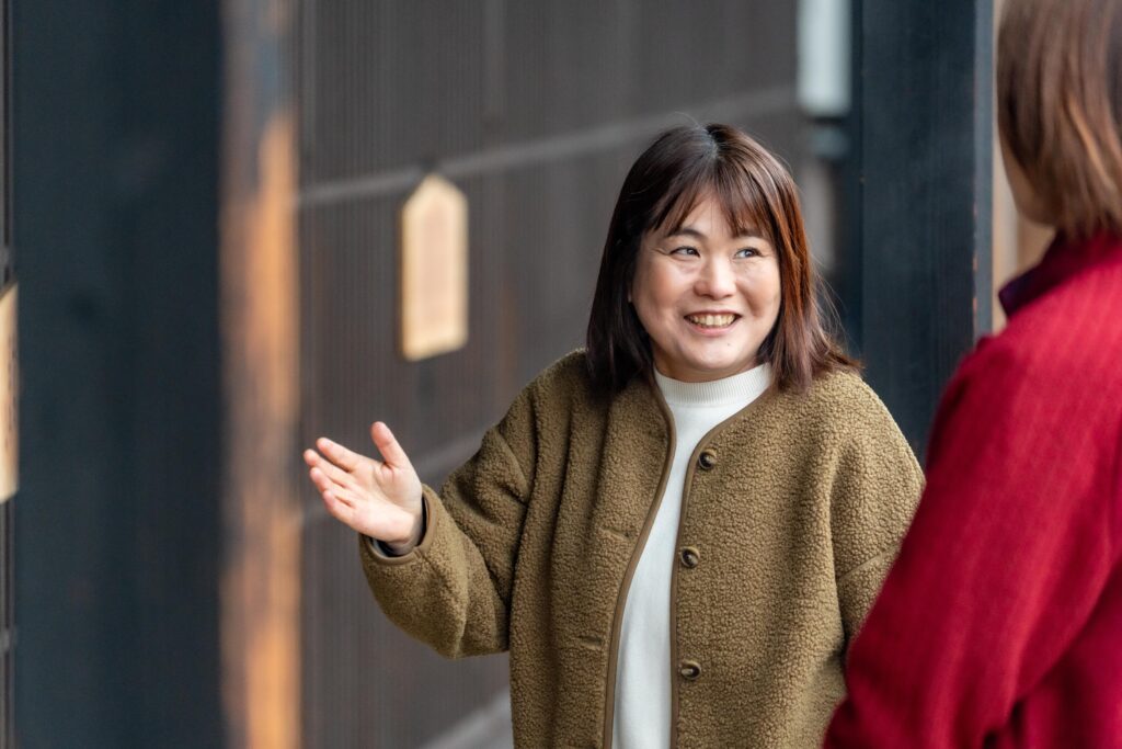 笑顔で身振り手振りを交えながら、楽しそうに観光案内をするガイドグループ雪彩の女性ガイド。